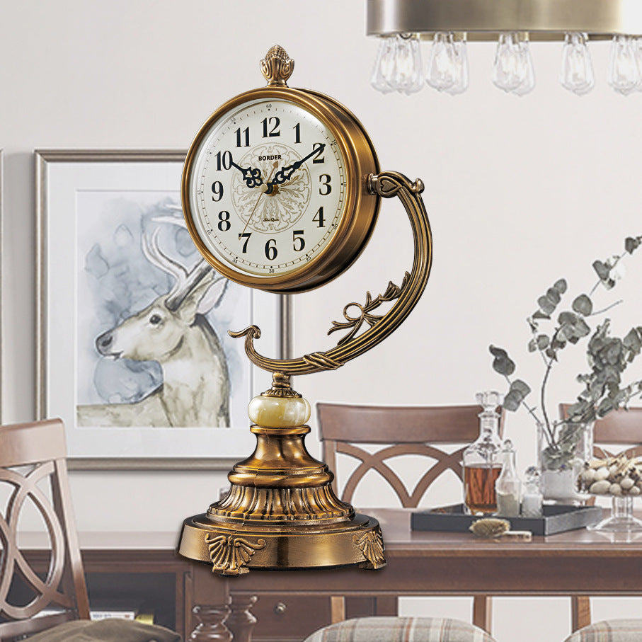 Decorative table clock with gold finish on a table in a room setting.